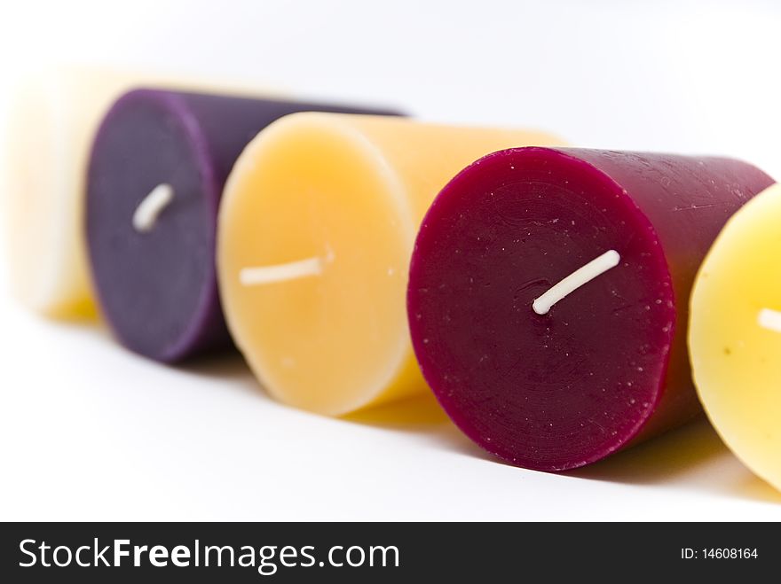 Five multi-colored wax candles lying on white surface. Five multi-colored wax candles lying on white surface