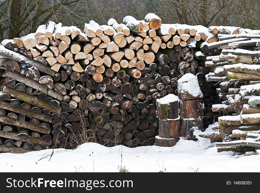 A snowy stack of logs of firewood