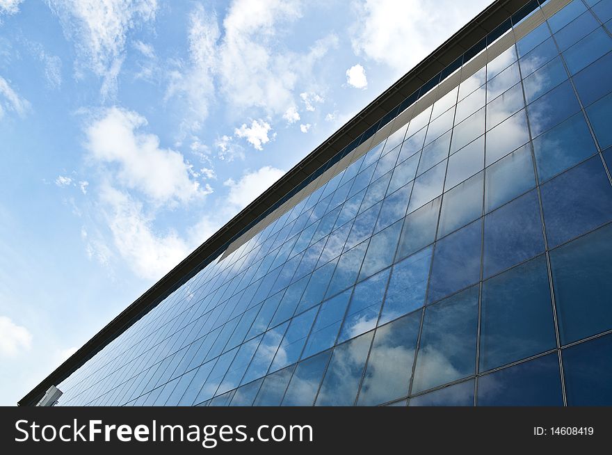 A building reflecting the blue sky on it's exterior. A building reflecting the blue sky on it's exterior