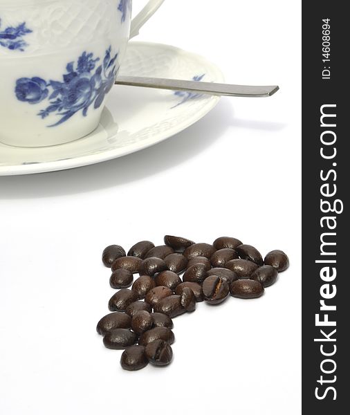 Coffee beans in front of cup and saucer. Coffee beans in front of cup and saucer