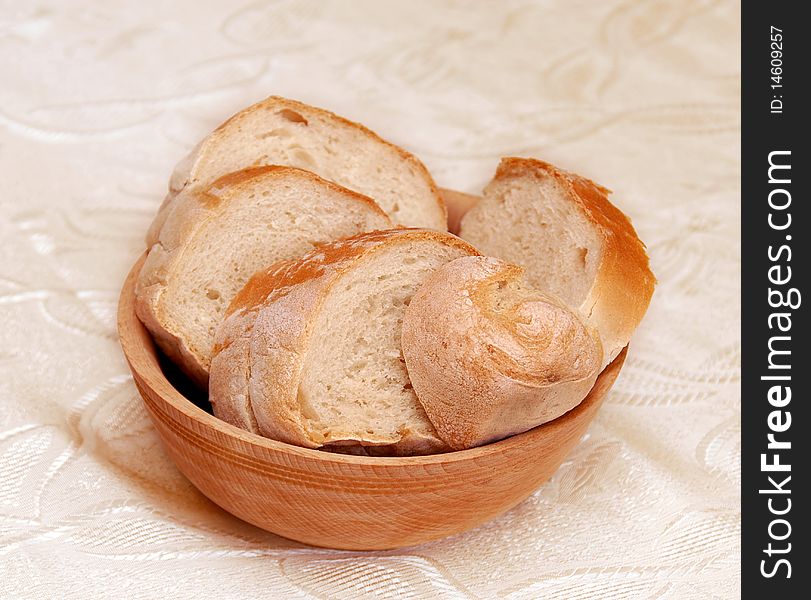 White wheat bread slices served in wooden bowl on table