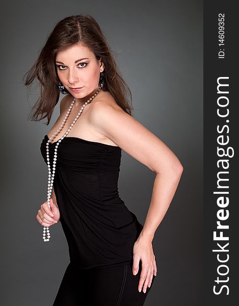 Elegant woman in black dress with gray background
