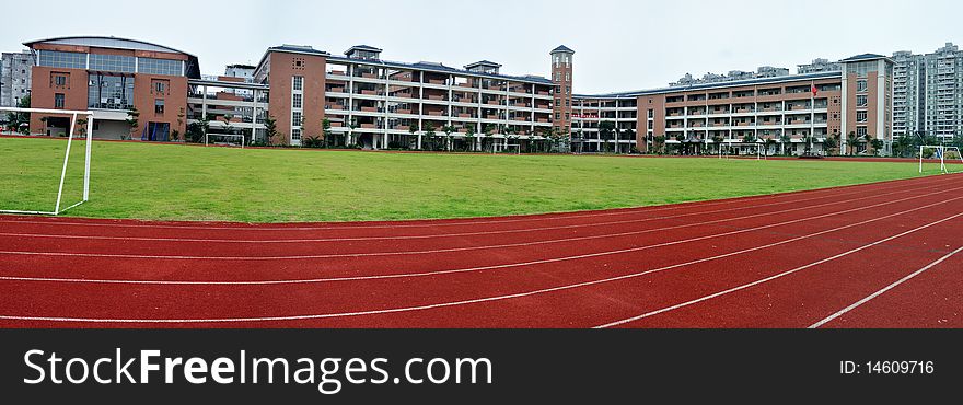View of a new shool building,red track and outdoor green field. View of a new shool building,red track and outdoor green field