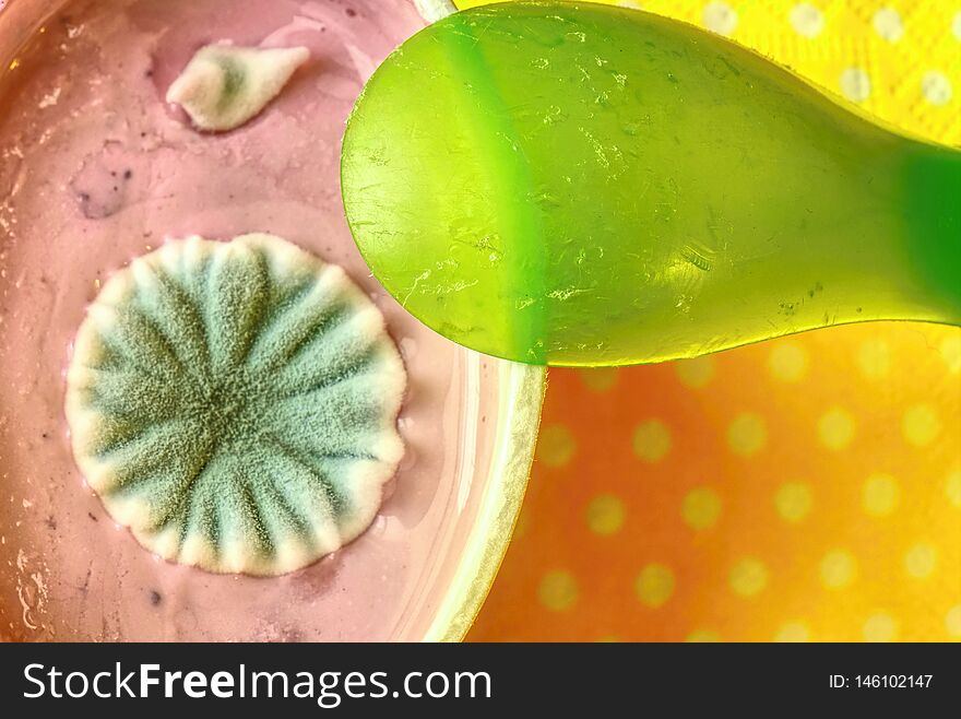 Yogurt in plastic cup close up with small spoon, top view photo of strawberry yoghurt on wooden background. Yogurt in plastic cup close up with small spoon, top view photo of strawberry yoghurt on wooden background
