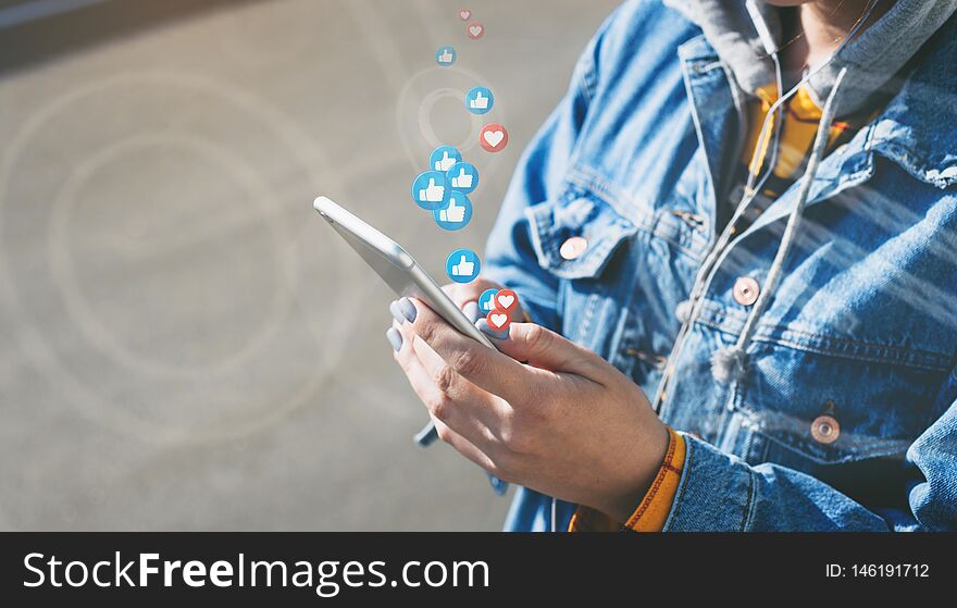 Young woman watches live stream while walking down city street