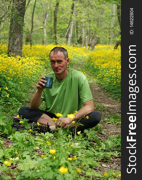 A young man drinks tea while resting during a hike. Early Spring in the Crimean mountains. A young man drinks tea while resting during a hike. Early Spring in the Crimean mountains.