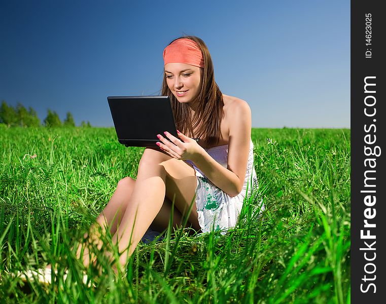 Beautiful girl with notebook on grass