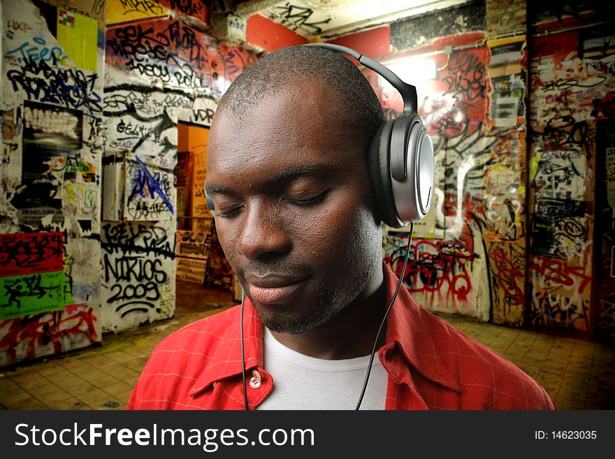 Black man listening to music with graffiti on the background. Black man listening to music with graffiti on the background