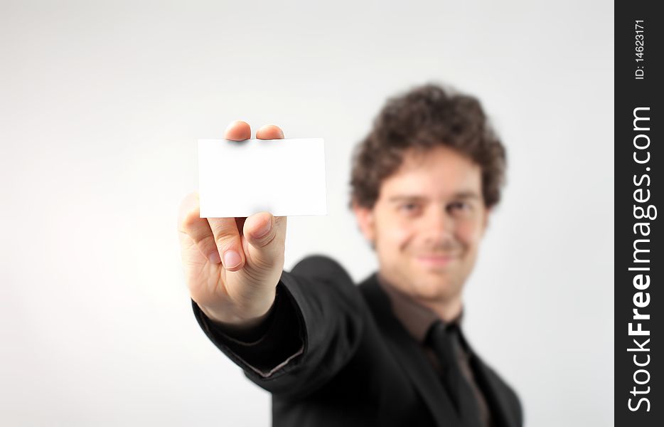 Smiling businessman showing a card. Smiling businessman showing a card