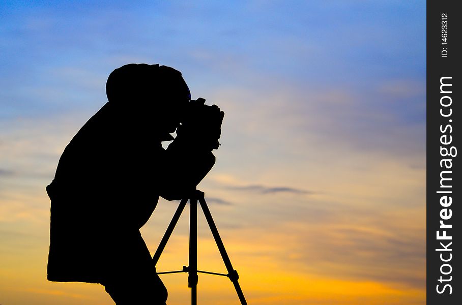 Photographer posing in sunset with beautiful sky. Photographer posing in sunset with beautiful sky