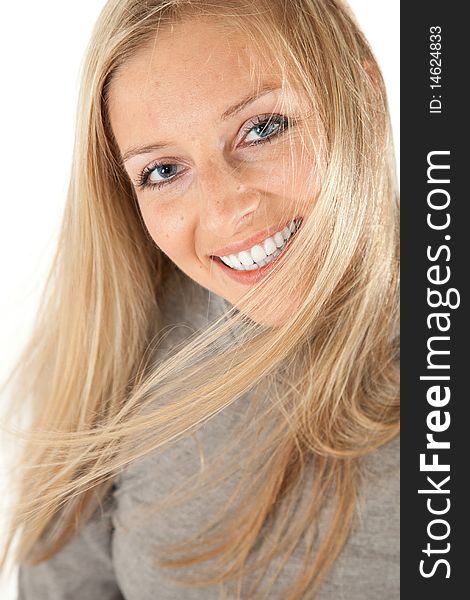 Caucasian blond girl portrait in gray outfit on white background smiling