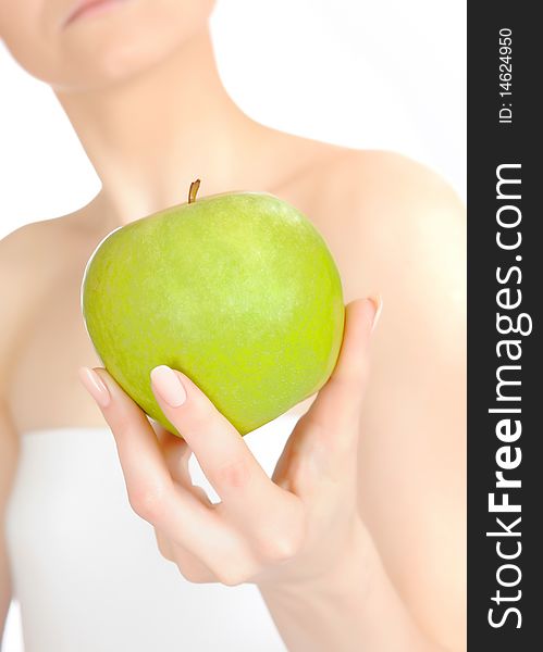 Green apple in a beautiful hand of woman. white background