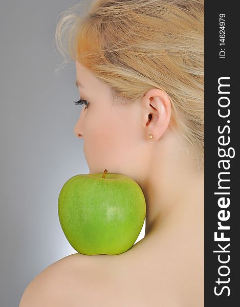 Young woman holding green apple on  her shoulder