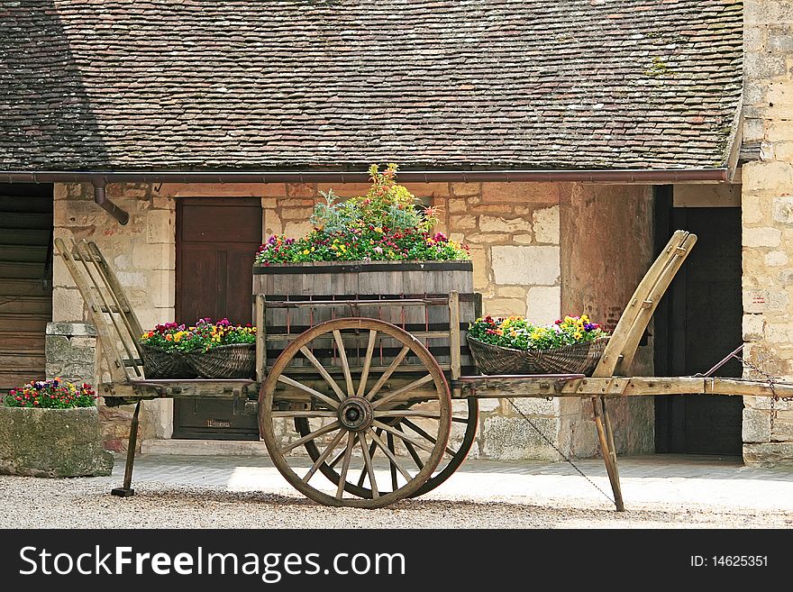 Old wheel cart with flowers on top