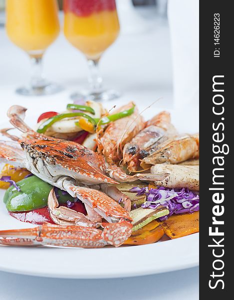 Fresh seafood meal of swimming crab and tiger shrimps with salad on a white plate with fresh fruit drinks. Fresh seafood meal of swimming crab and tiger shrimps with salad on a white plate with fresh fruit drinks