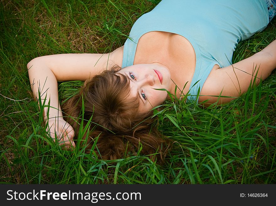 Portrait of a beautiful female lying on a grass, it is summer and she is relaxing. Portrait of a beautiful female lying on a grass, it is summer and she is relaxing