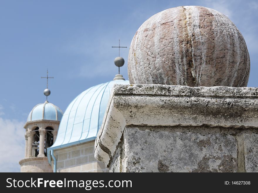 Stone sphere on a pedestal against blue domes of Montenegro church. Stone sphere on a pedestal against blue domes of Montenegro church.