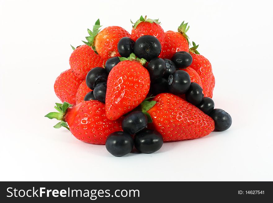 Heap of sweet strawberries and blueberries isolated on white