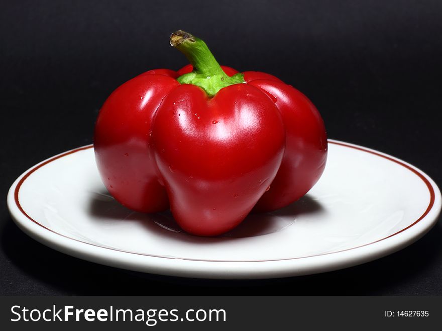 Red bell pepper on black background.