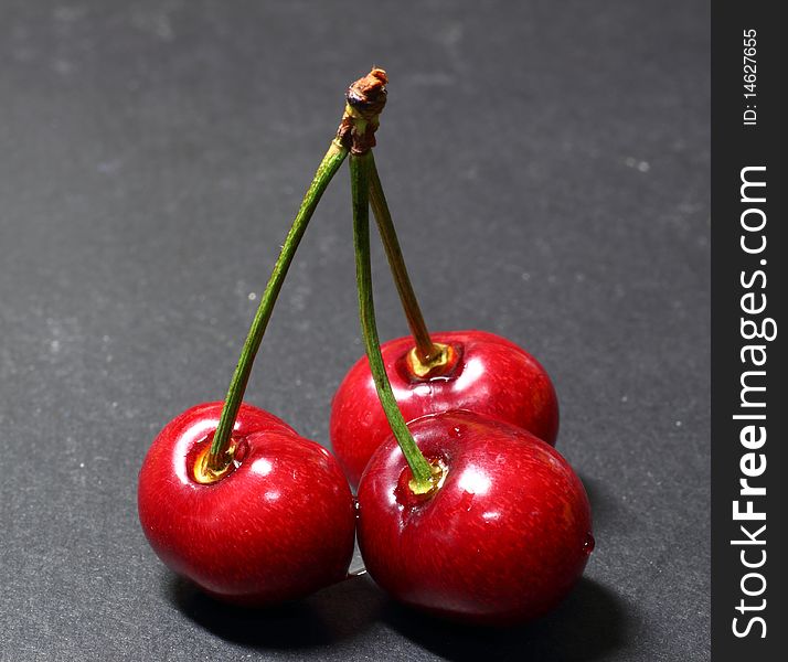 Red cherry on black background.