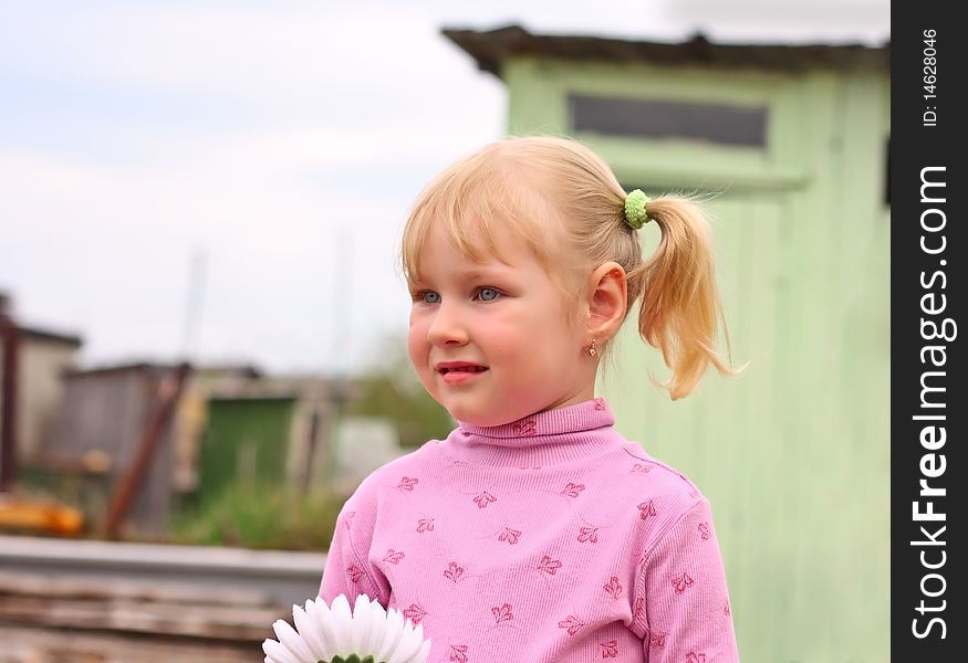 Girl with a flower in a pink blouse. Outdoor looks into the distance. Girl with a flower in a pink blouse. Outdoor looks into the distance