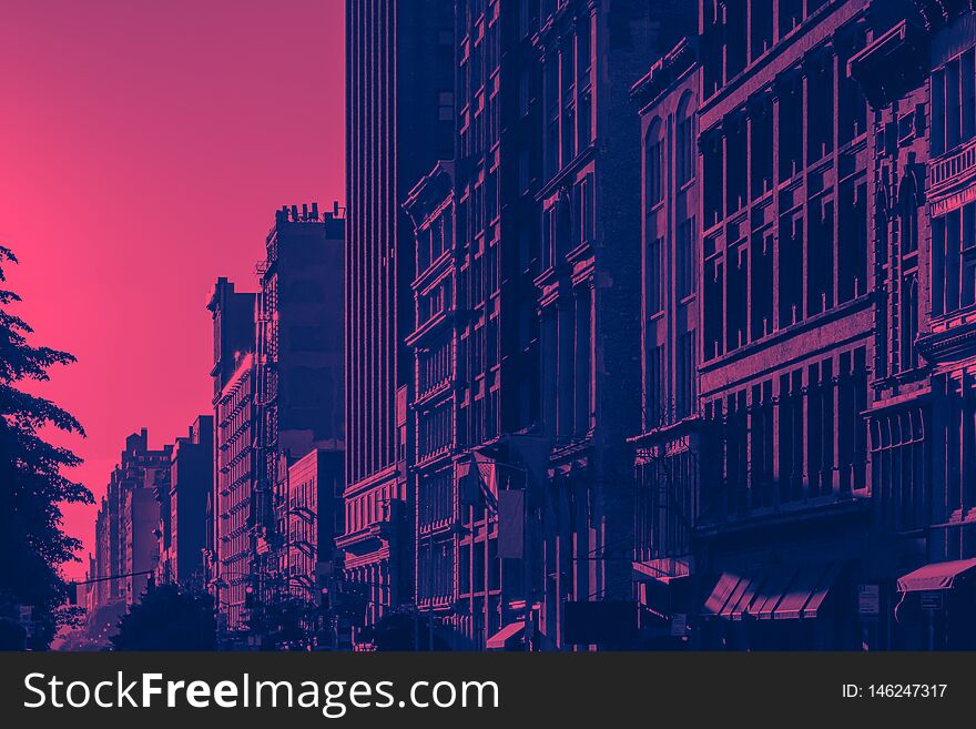 Sunlight shines on New York City buildings with pink and blue color