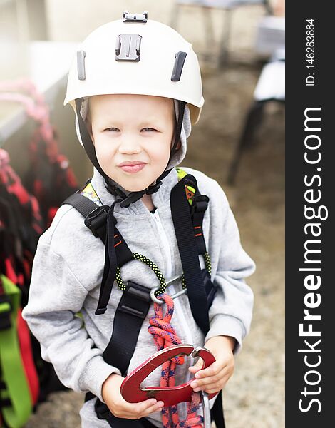 Caucasian boy in a climbing helmet before the start of the passage of obstacles