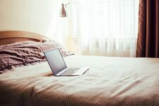 New Laptop With Blank Screen On Bed Blanket In Home Bedroom Interior Royalty Free Stock Photo