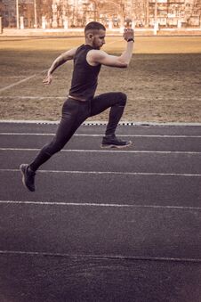 One Caucasian Male Is Doing A Sprint Start. Running On The Rubber Track. Track And Field Runner In Sport Uniform. Energetic Royalty Free Stock Photography