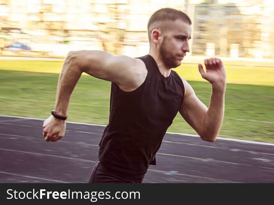 One caucasian male is doing a sprint start. running on the stadium on a rubber track. Track and field runner in sport uniform. energetic physical activities. outdoor exercise, healthy lifestyle