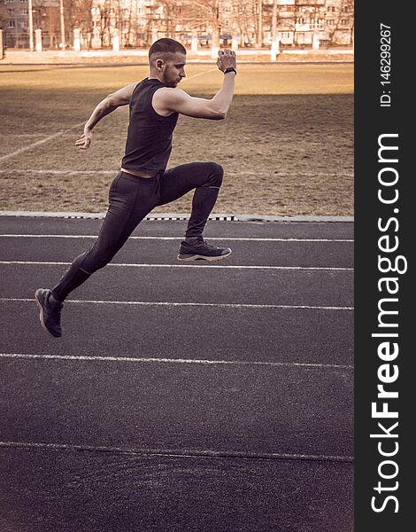 One caucasian male is doing a sprint start. running on the rubber track. Track and field runner in sport uniform. energetic