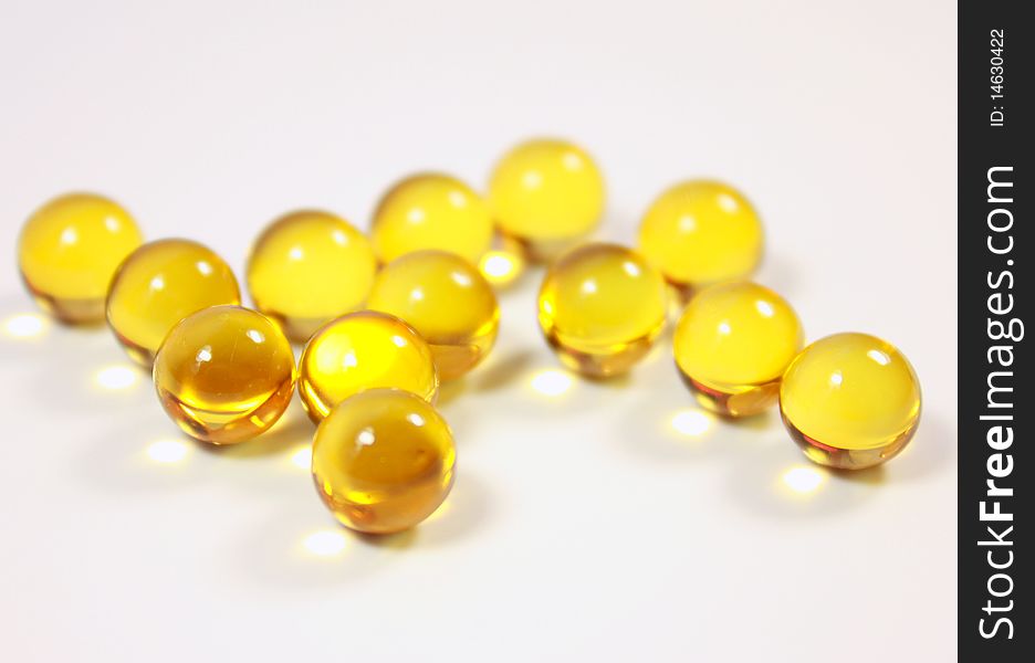 Dragees (vitamins) of yellow colour lie on a table