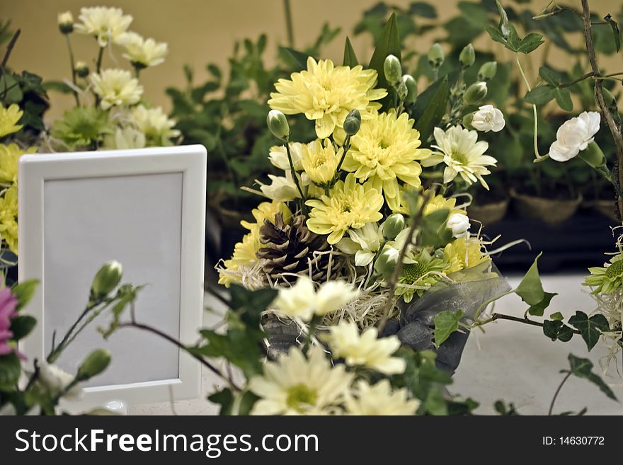 A group of fresh flower arrangments with an empty white frame