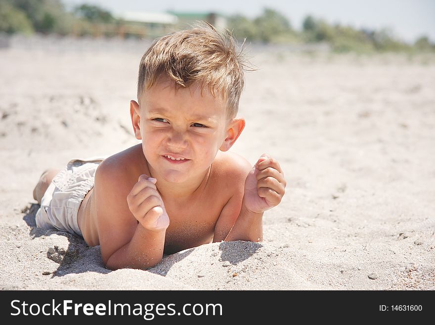 Young Boy Laying On Beach