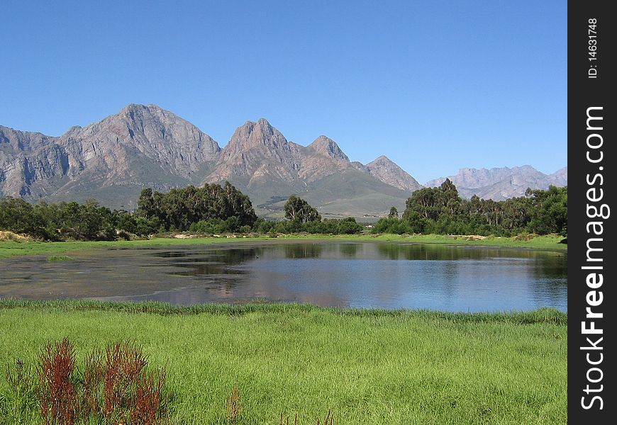 The Audensberg reflects in the waters of a nearby rural dam in Worcester, Western Cape, South Africa. The Audensberg reflects in the waters of a nearby rural dam in Worcester, Western Cape, South Africa