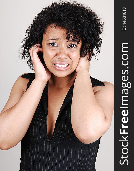 An very scared Hispanic woman putting her hands to the head, almost 
crying, on light gray background. An very scared Hispanic woman putting her hands to the head, almost 
crying, on light gray background.