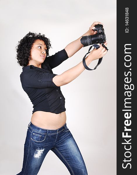 A pretty Hispanic woman try to take a picture of herself
in a black blouse and jeans, over light gray. A pretty Hispanic woman try to take a picture of herself
in a black blouse and jeans, over light gray.