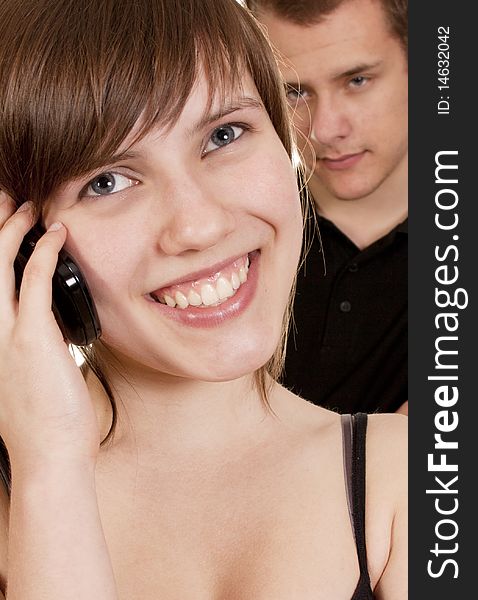 Young woman is phoning and her boyfriend is suspicious. Young woman is phoning and her boyfriend is suspicious