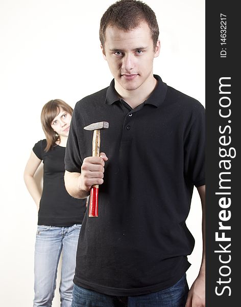 The picture presents a pair of people - woman, looking enquirely and man with a hammer, looking determinedly and trying to show, that he is dominant and stronger. The picture presents a pair of people - woman, looking enquirely and man with a hammer, looking determinedly and trying to show, that he is dominant and stronger.