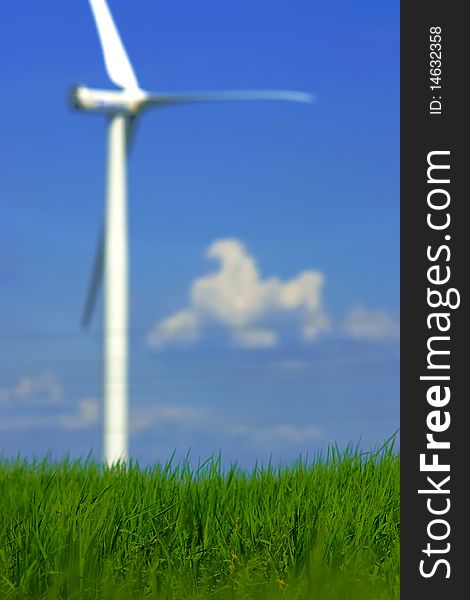 Ecological concept of grass closeup with blurry wind power in background. Ecological concept of grass closeup with blurry wind power in background.