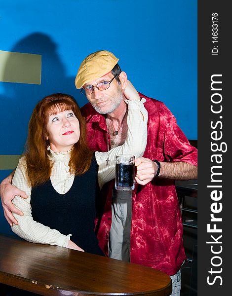Red woman and man in cap with mug with beer