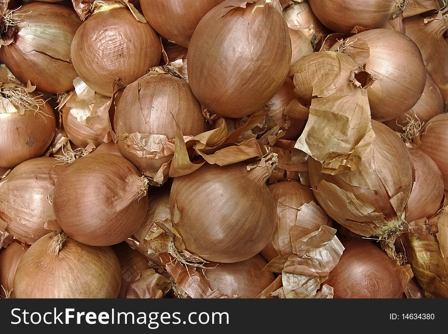 A background of lots of yellow onions piled up