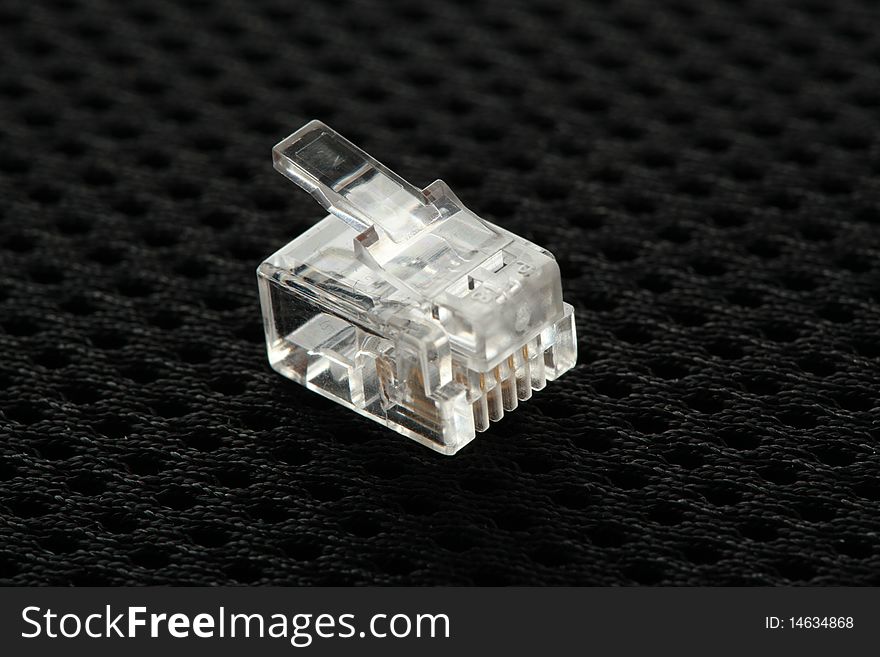 Connector for telephone cable on a black background. Connector for telephone cable on a black background