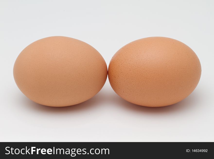 Two eggs kissing each other isolated on a white background. Two eggs kissing each other isolated on a white background