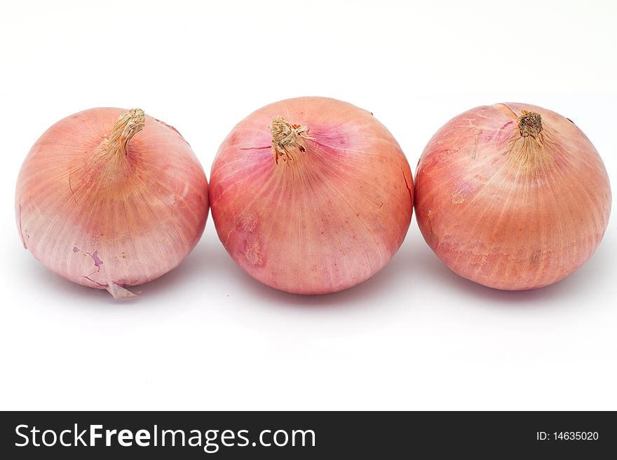 Three onions in a row isolated on a white background