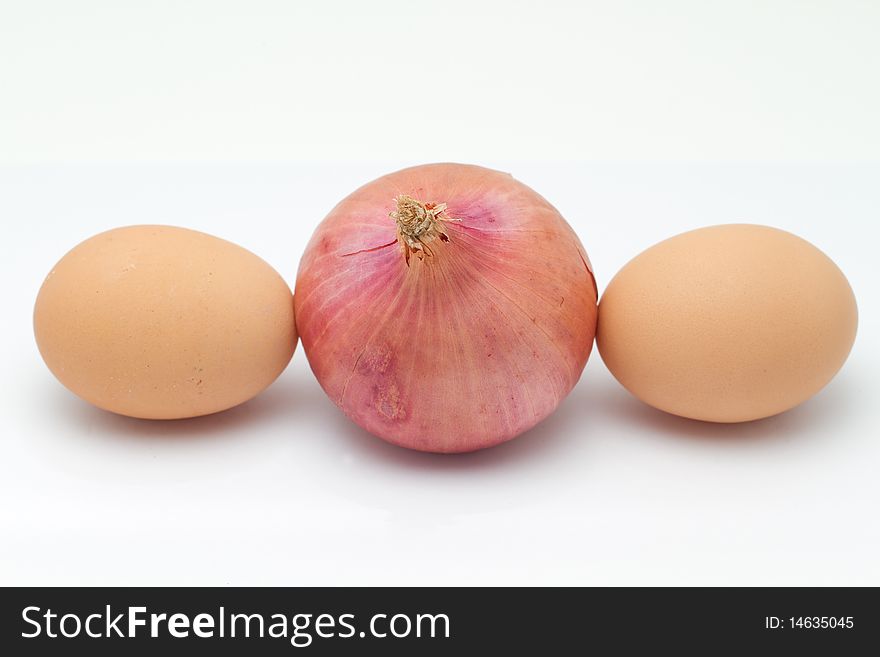 An onion nip between two eggs isolated on a white background. An onion nip between two eggs isolated on a white background