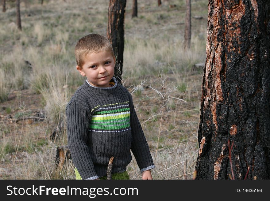 Young blond boy playing outside in the field