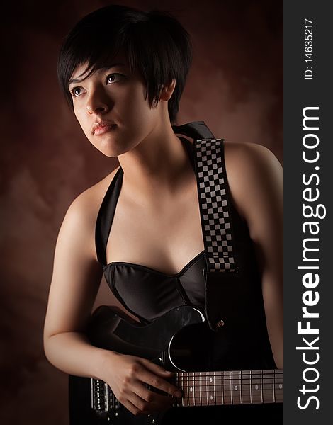 Attractive Multiethnic Girl Plays Her Guitar