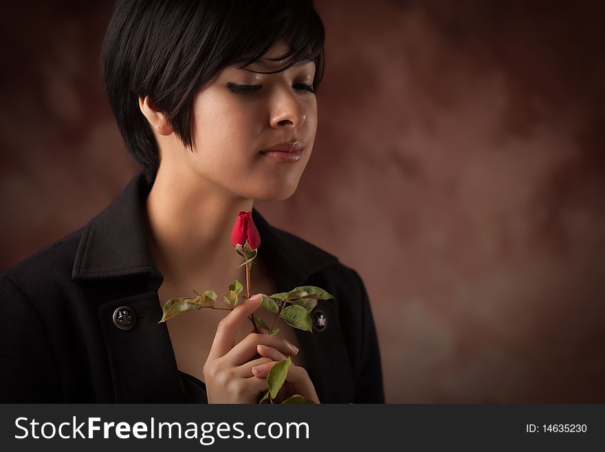 Pretty Multiethnic Young Adult Woman Holding a Single Rose Portrait with Selective Focus. Pretty Multiethnic Young Adult Woman Holding a Single Rose Portrait with Selective Focus.