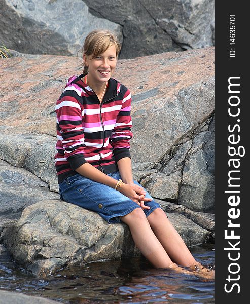 Beautiful girl sitting with her feet in the water. Beautiful girl sitting with her feet in the water